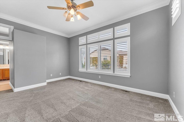 carpeted empty room featuring visible vents, ornamental molding, and baseboards