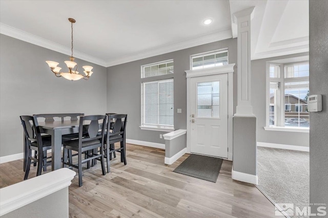 dining room with baseboards, plenty of natural light, a chandelier, and crown molding