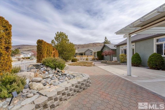 view of patio / terrace featuring fence and a mountain view