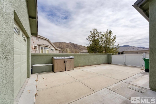 view of patio / terrace with a gate, a mountain view, and fence