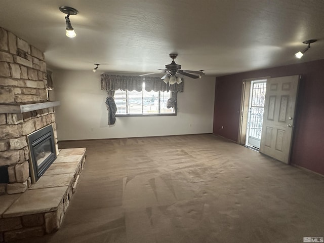 unfurnished living room with carpet floors, ceiling fan, and a fireplace