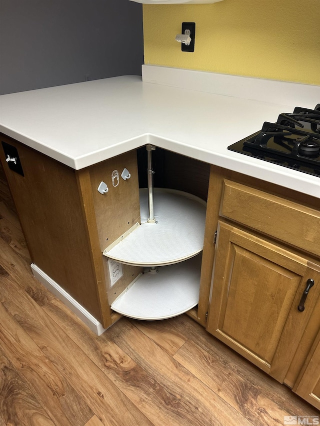 room details featuring black gas cooktop, light countertops, and wood finished floors