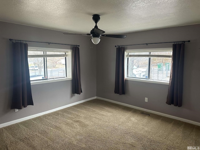 unfurnished room with a healthy amount of sunlight, baseboards, visible vents, and carpet flooring