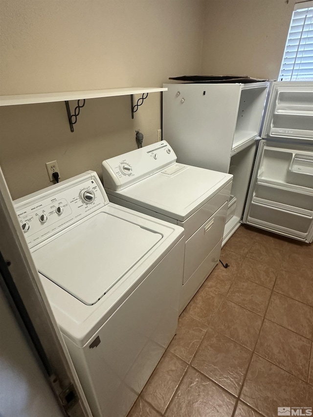 laundry room featuring dark tile patterned flooring, laundry area, and separate washer and dryer