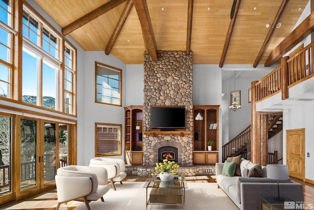 living room with wooden ceiling, stairs, a fireplace, and high vaulted ceiling