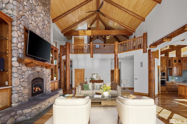 unfurnished living room with beam ceiling, a fireplace, wood ceiling, wood finished floors, and high vaulted ceiling