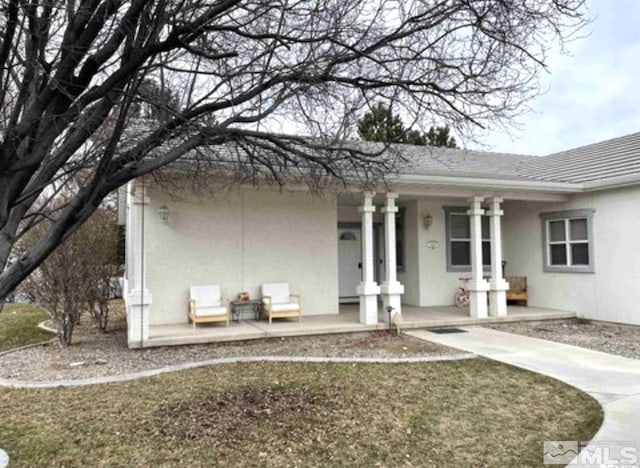 exterior space featuring covered porch and stucco siding