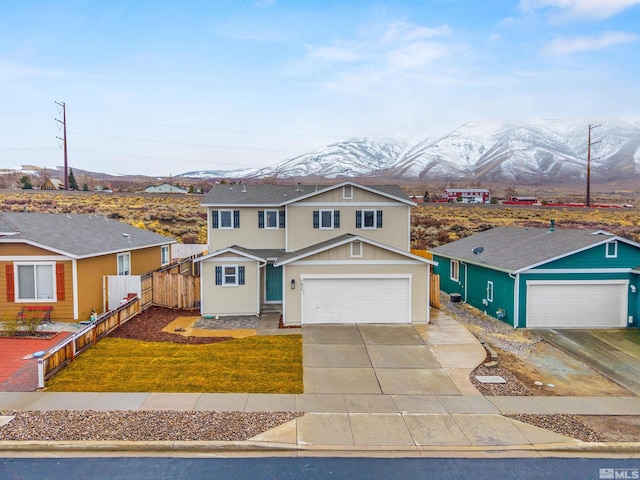 traditional-style home with driveway, a front lawn, fence, and a mountain view