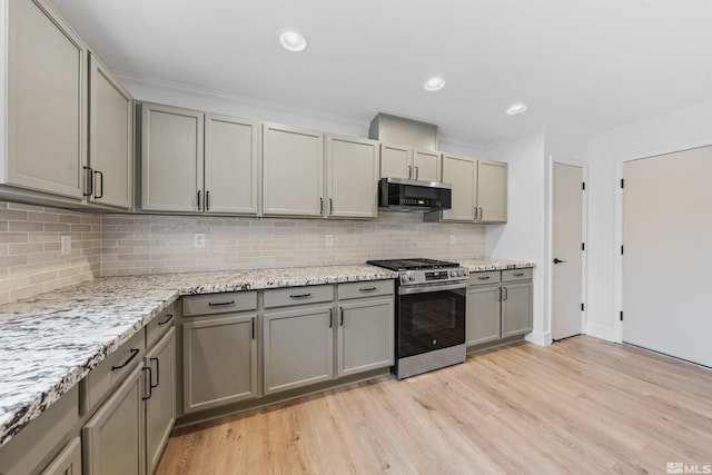 kitchen featuring gray cabinetry, ornamental molding, appliances with stainless steel finishes, light wood-type flooring, and backsplash