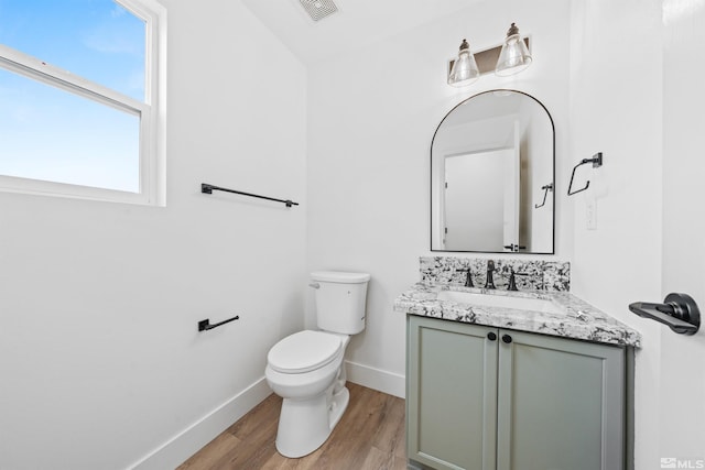 bathroom featuring toilet, wood finished floors, visible vents, vanity, and baseboards