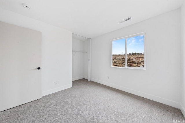 unfurnished bedroom featuring carpet floors, baseboards, visible vents, and a closet