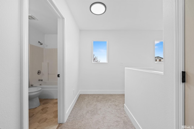 bathroom with visible vents, tub / shower combination, toilet, and baseboards