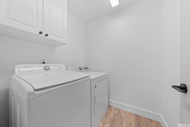 laundry room with baseboards, cabinet space, washer and clothes dryer, and light wood finished floors