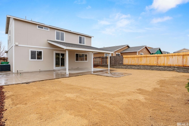 rear view of property featuring a patio, central AC unit, and a fenced backyard