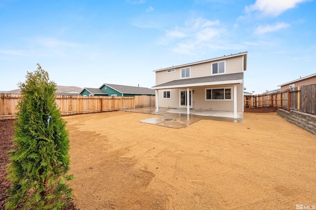 rear view of property featuring a patio area and a fenced backyard