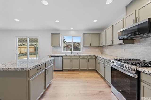 kitchen featuring appliances with stainless steel finishes, light wood-type flooring, a sink, and gray cabinetry