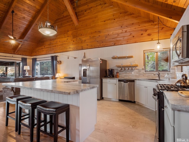 kitchen featuring a wealth of natural light, decorative backsplash, stainless steel appliances, and a sink