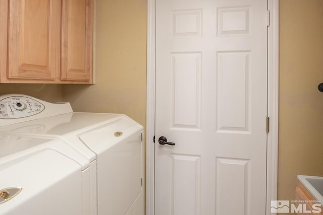 clothes washing area featuring cabinet space and washing machine and clothes dryer