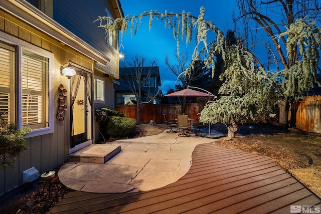 wooden terrace with a patio area and a fenced backyard