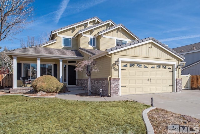 craftsman inspired home with a garage, concrete driveway, a tile roof, fence, and a front lawn