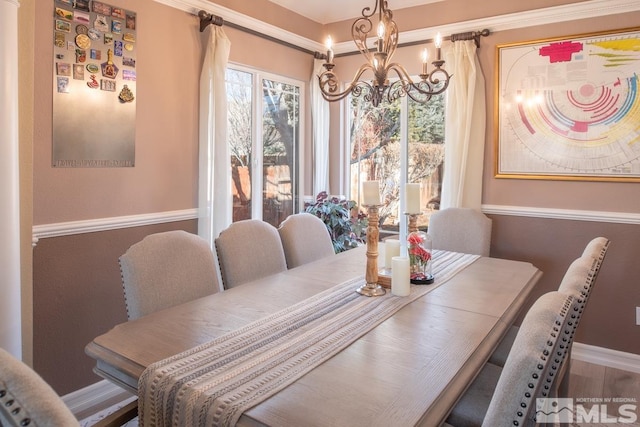 dining space with baseboards and a notable chandelier