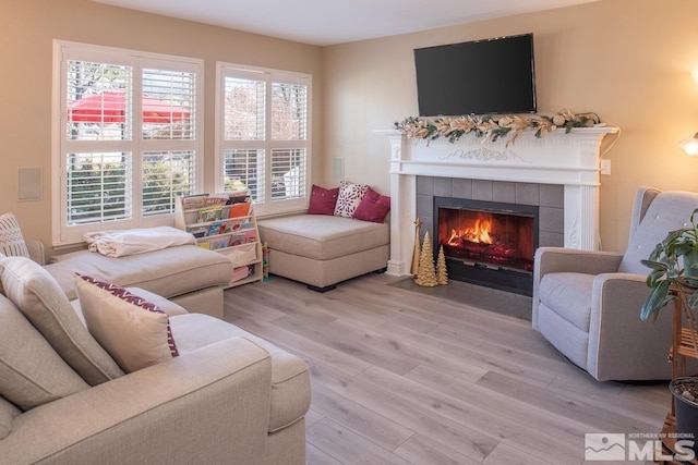 living area with light wood finished floors and a tile fireplace