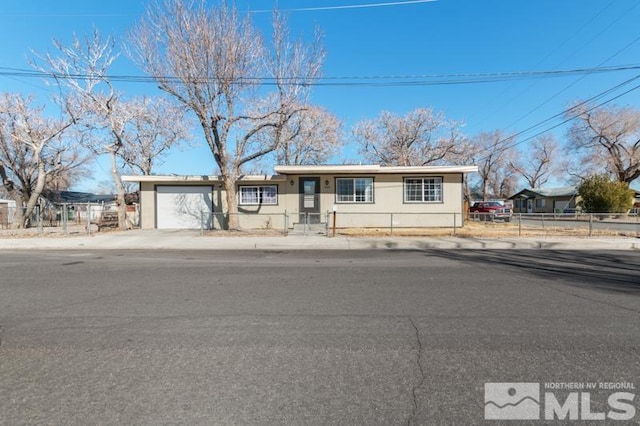 ranch-style home featuring a garage and a fenced front yard