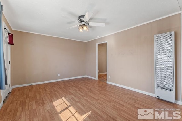 spare room with ornamental molding and light wood-type flooring