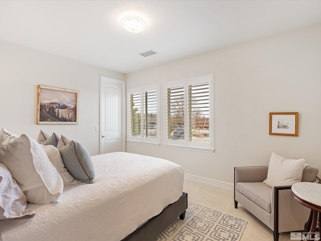 bedroom with baseboards, visible vents, and light colored carpet