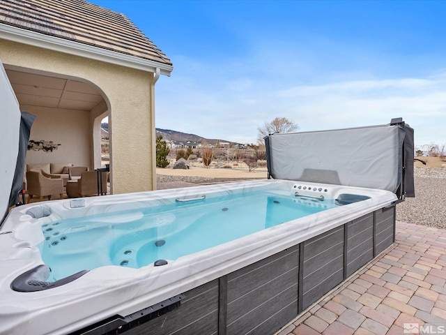 view of pool featuring a mountain view and a hot tub