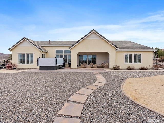 rear view of house with a patio area, an outdoor living space, and stucco siding