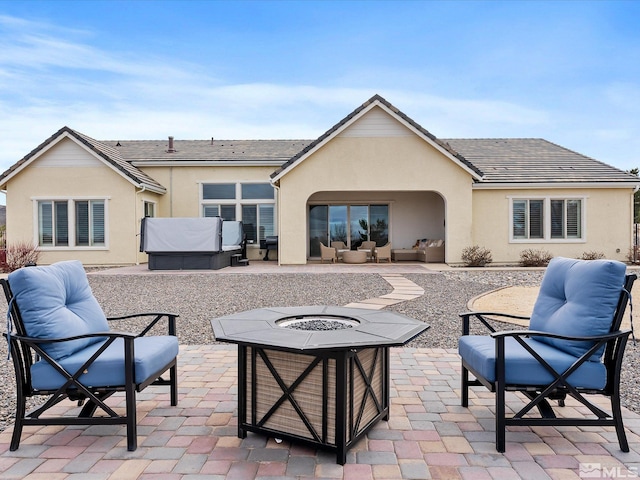 rear view of house with a patio area and stucco siding