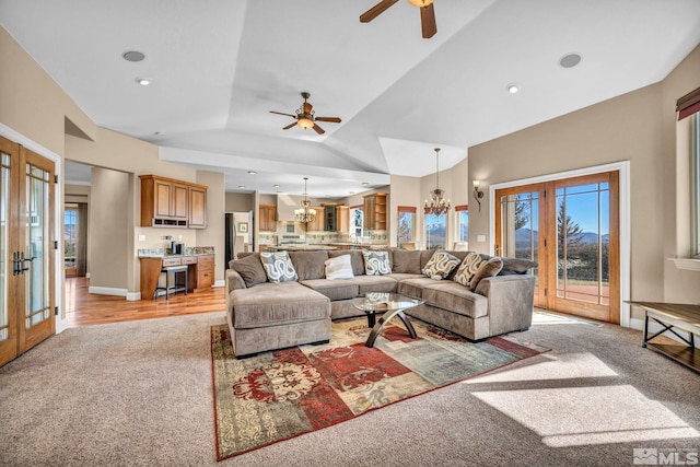 living area with french doors, lofted ceiling, light carpet, baseboards, and ceiling fan with notable chandelier