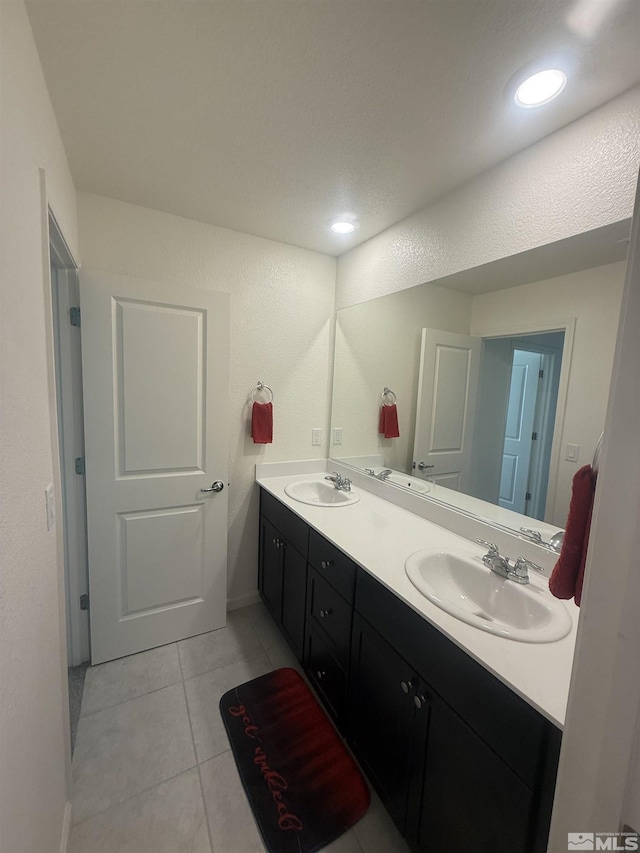 bathroom featuring double vanity, a sink, and tile patterned floors