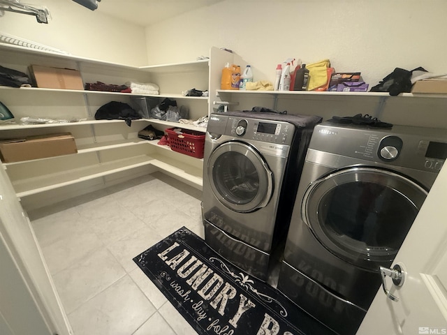 laundry room with laundry area, washing machine and dryer, and tile patterned floors