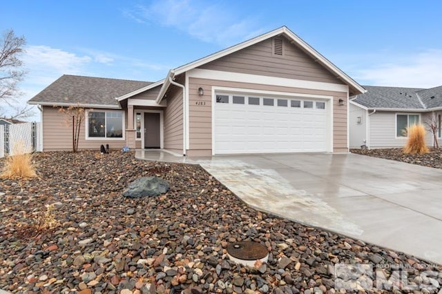 ranch-style house with a garage, roof with shingles, driveway, and fence