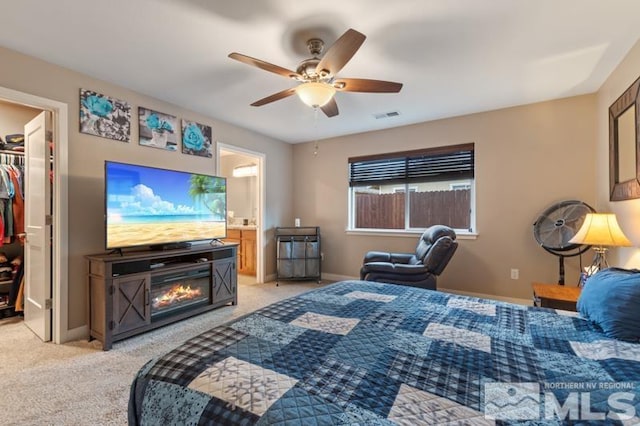 bedroom featuring a spacious closet, visible vents, baseboards, light colored carpet, and a closet