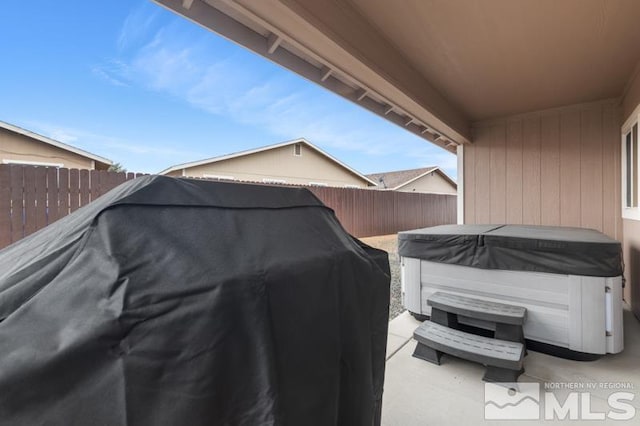 view of patio featuring area for grilling, a fenced backyard, and a hot tub