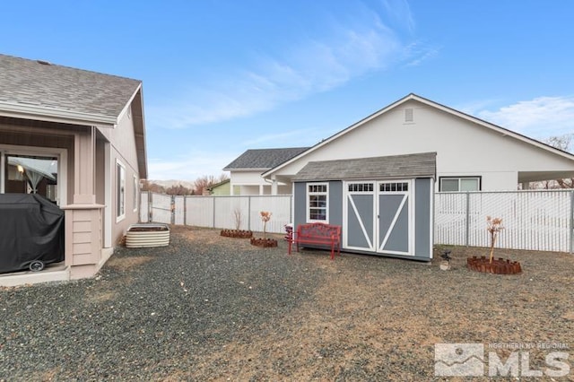 view of yard featuring an outdoor structure, a storage unit, and a fenced backyard