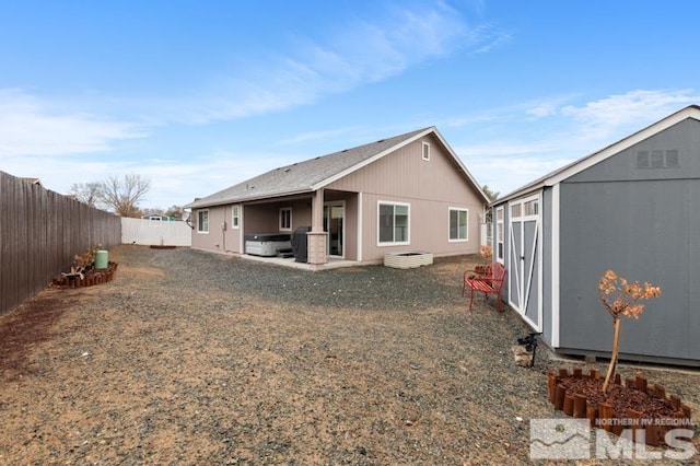 back of property with a patio, an outbuilding, a fenced backyard, and a shed