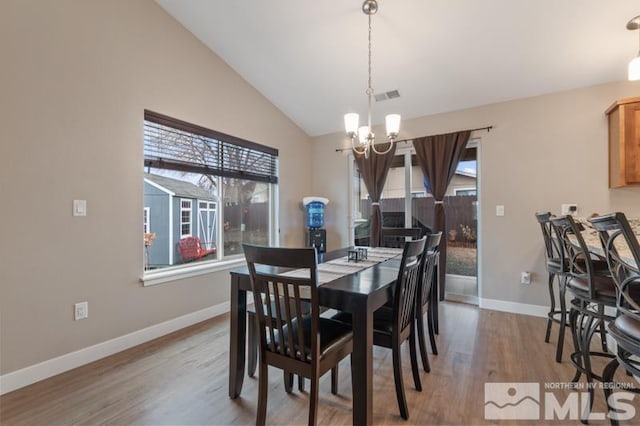 dining area with light wood-type flooring, visible vents, high vaulted ceiling, baseboards, and a chandelier