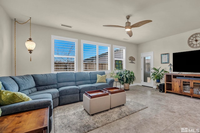 living room with ceiling fan, visible vents, and baseboards