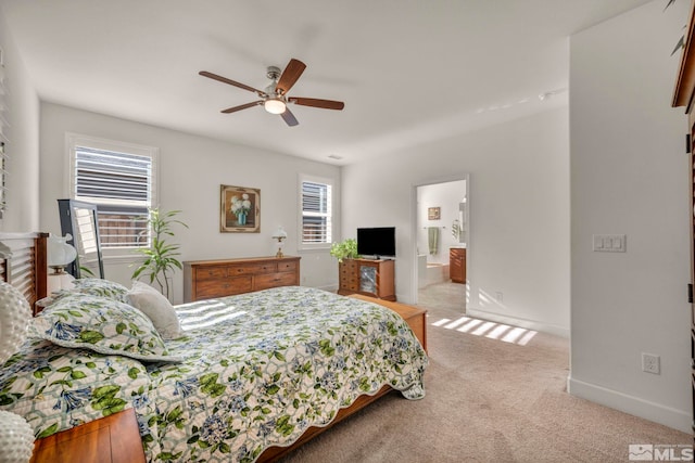 bedroom with light carpet, multiple windows, baseboards, and a ceiling fan