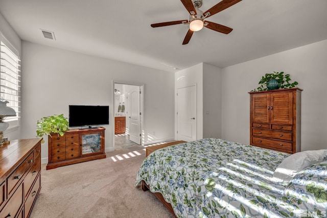 bedroom with baseboards, visible vents, connected bathroom, and light colored carpet