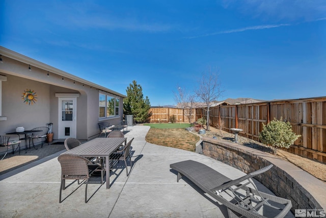 view of patio with outdoor dining space and a fenced backyard