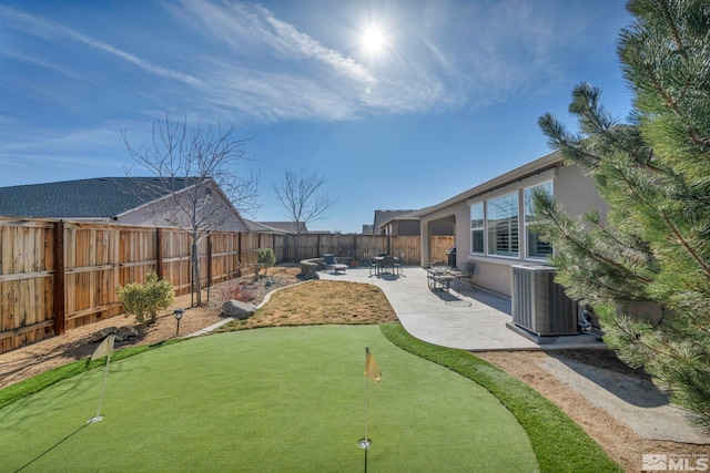 view of yard featuring a fenced backyard, central AC, and a patio