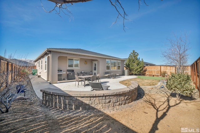 back of property with a fenced backyard, a patio, and stucco siding