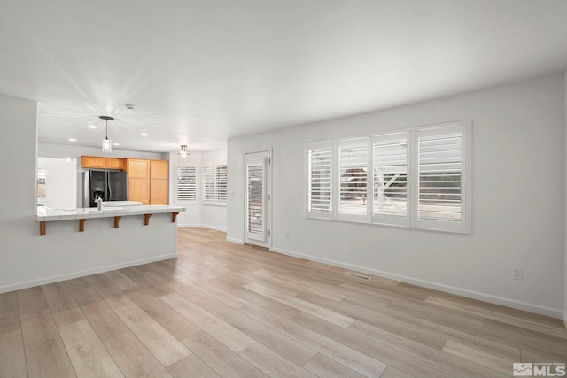 unfurnished living room with light wood-style floors, recessed lighting, visible vents, and baseboards