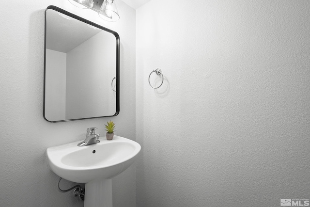 bathroom featuring a sink and a textured wall