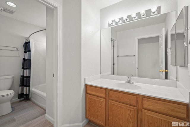 bathroom featuring toilet, wood finished floors, vanity, visible vents, and shower / bathtub combination with curtain